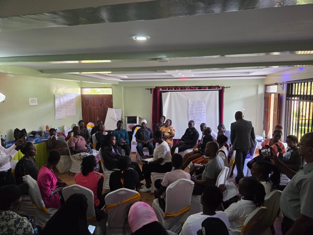 A large group seated in a hall during an app training session.