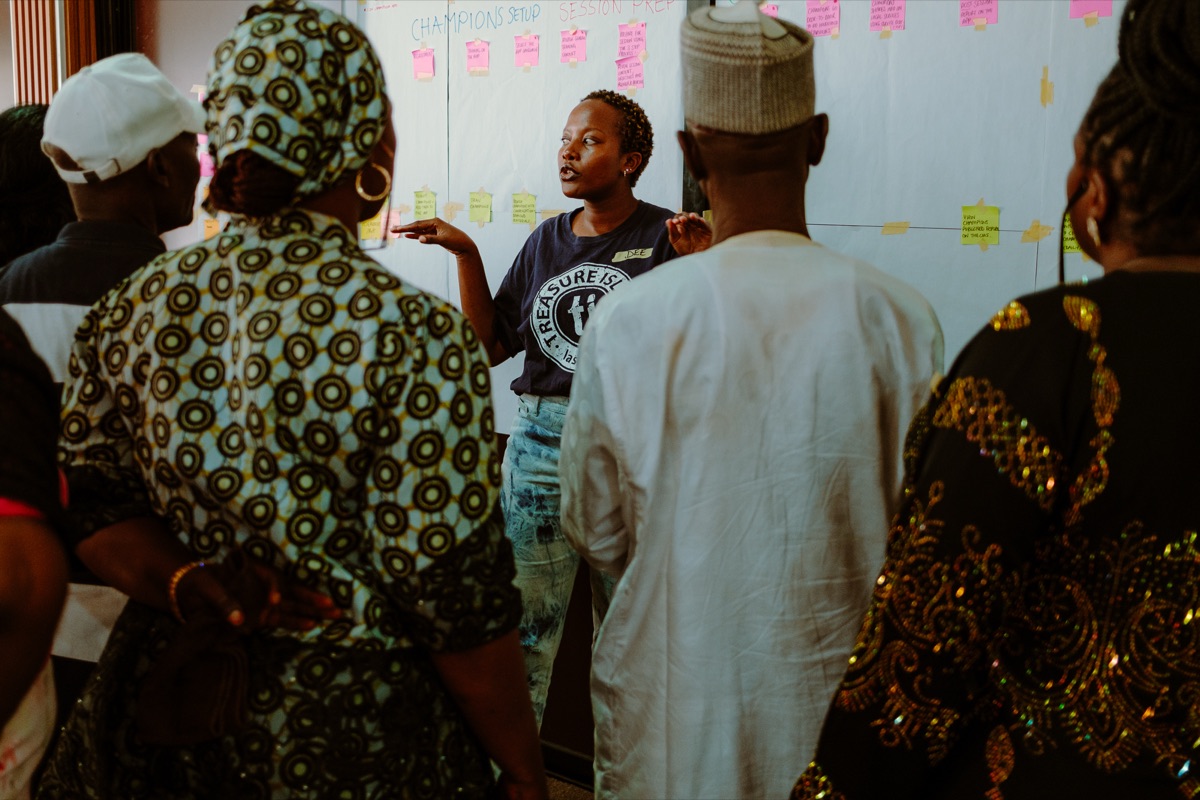 A facilitator leading a Champions co-creation workshop discussion in Abuja.