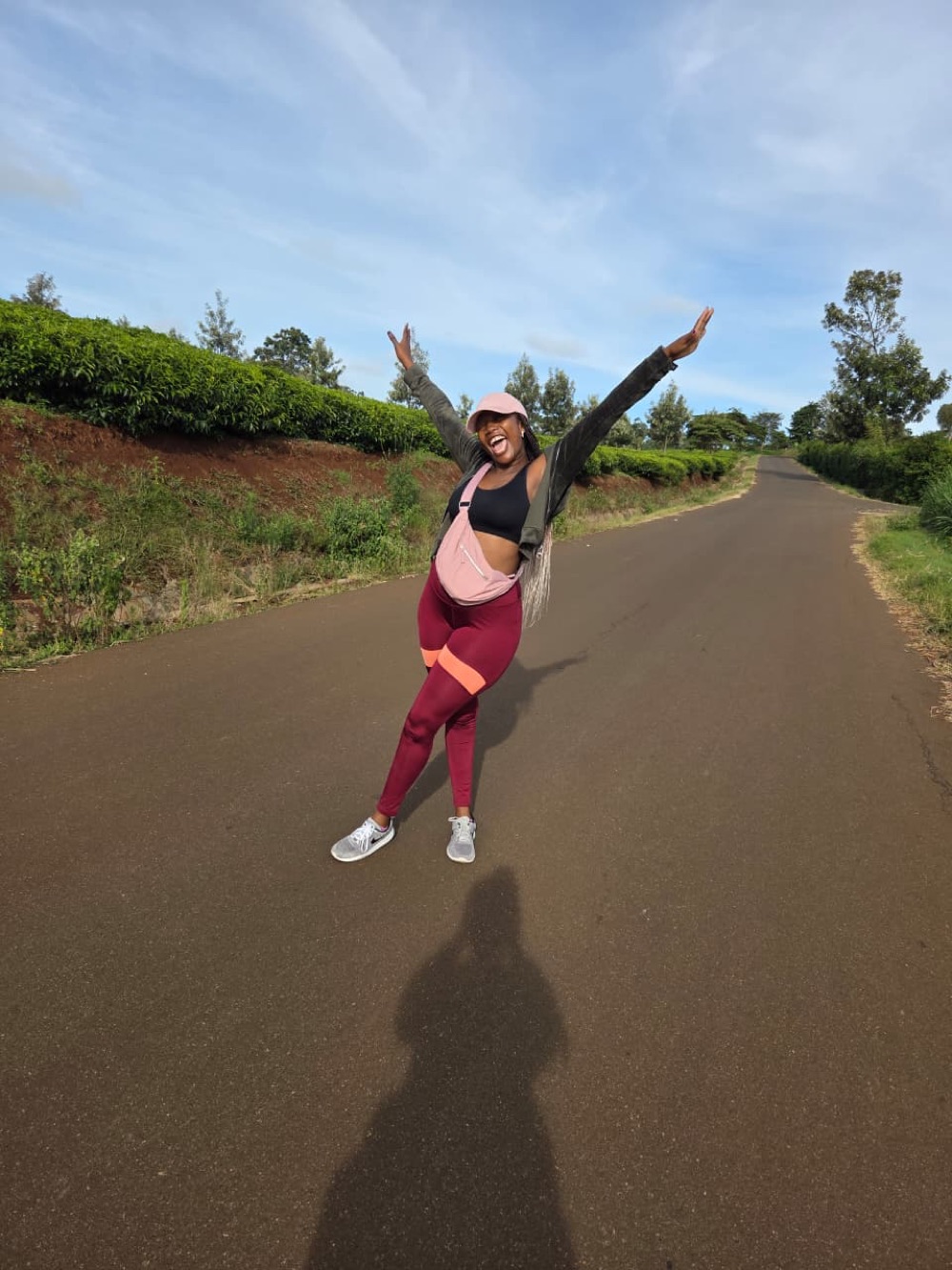 Diana leaping mid-stride on a quiet road lined with tea fields.